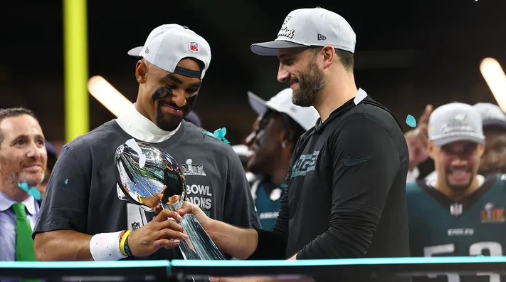 Philadelphia Eagles quarterback Jalen Hurts (1) and Philadelphia Eagles head coach Nick Sirianni celebrate with the Vince Lombardi Trophy after defeating the Kansas City Chiefs in Super Bowl LIX at Ceasars Superdome.